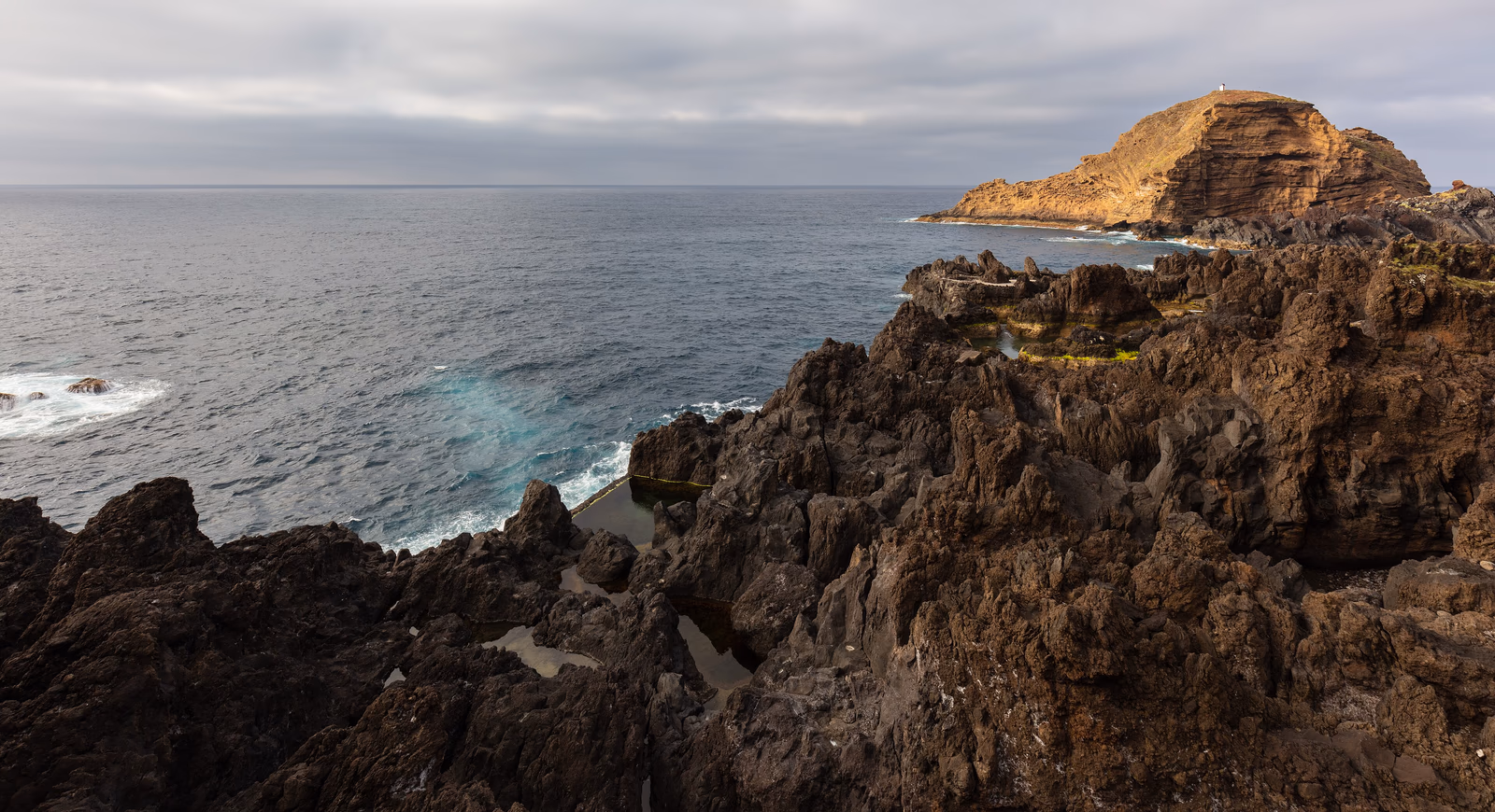 Vulkanische Naturbecken und dunkle Felsen an der Küste von Porto Moniz