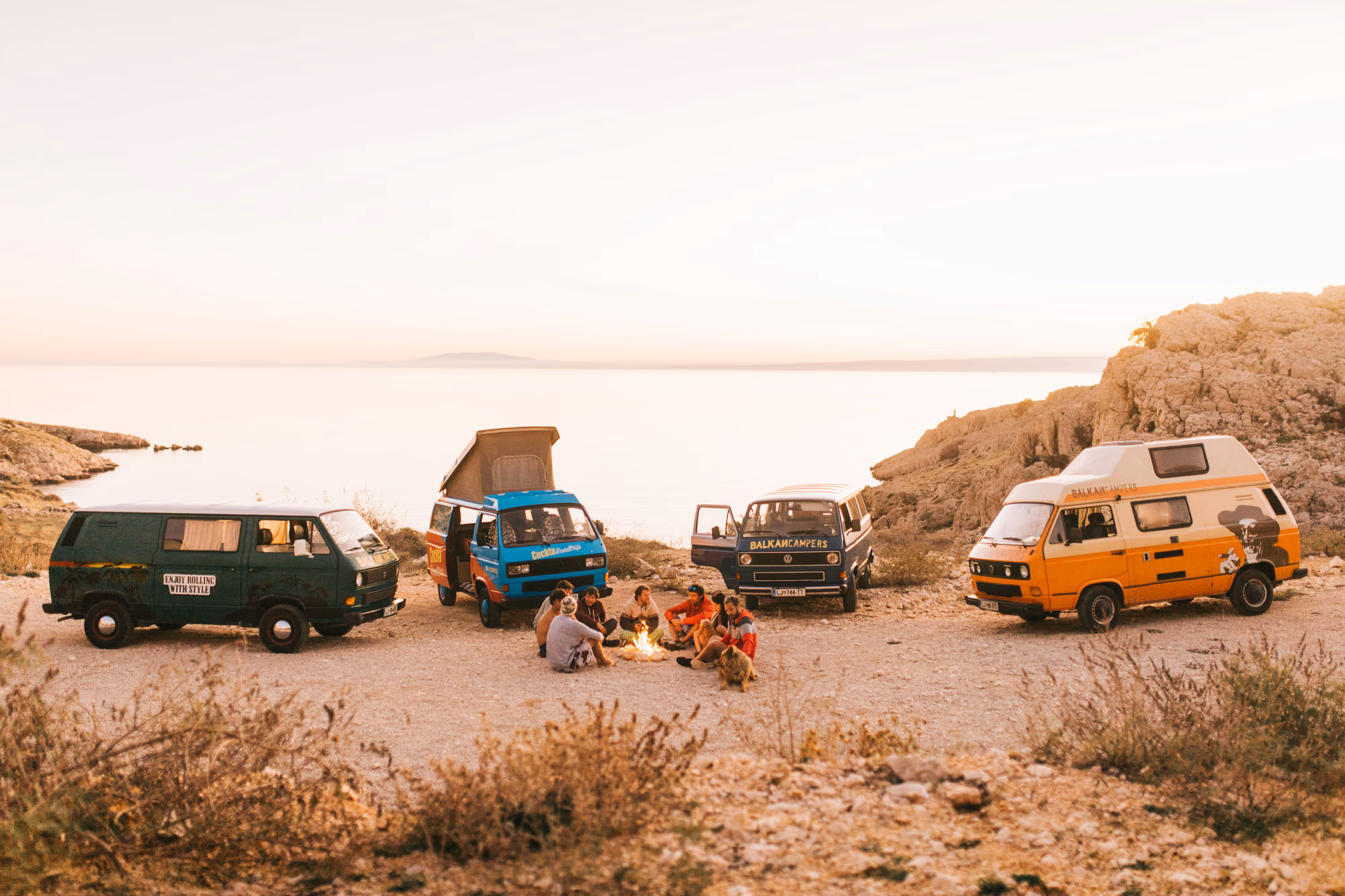 Vier farbige Campervans an der Küste