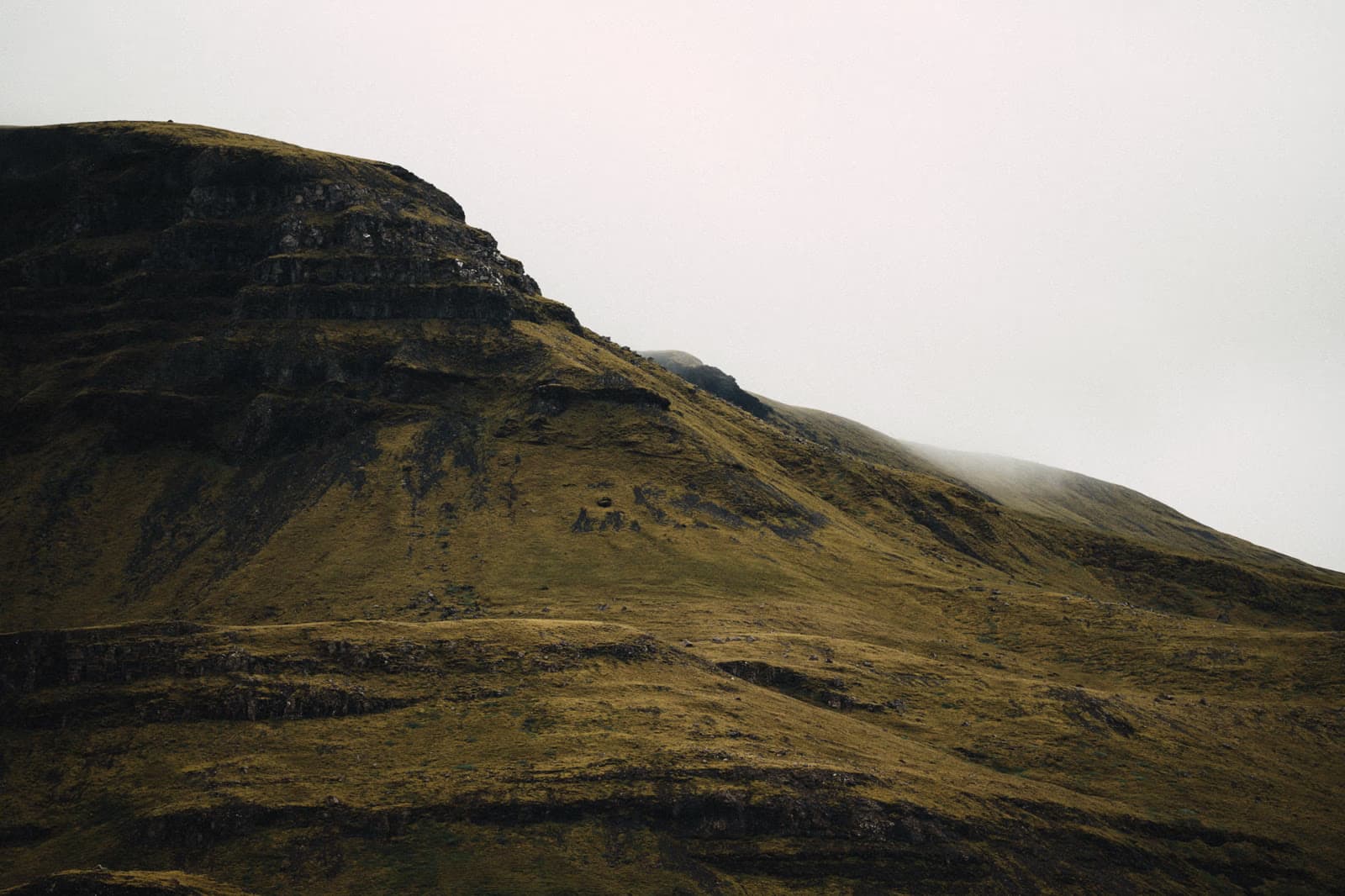 Weite isländische Landschaft unter tiefen Wolken