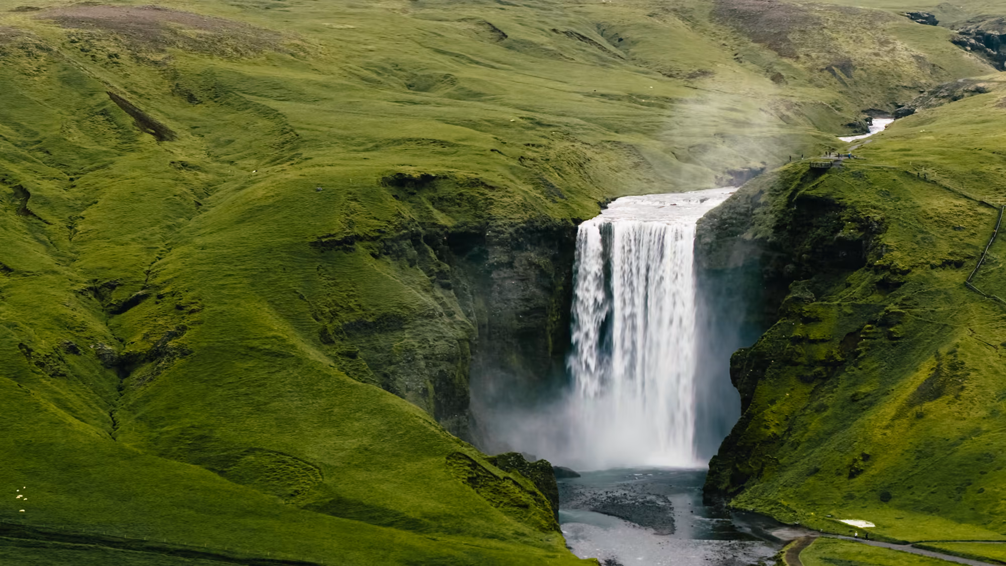 Luftaufnahme des Skógafoss in einer grünen Schlucht in Südisland