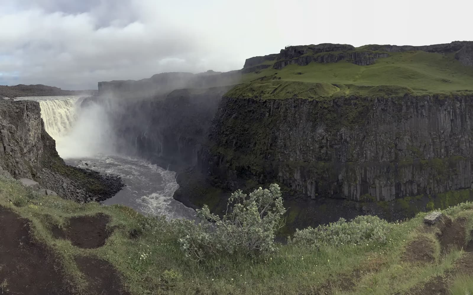 Dettifoss stürzt zwischen dunklen Basaltwänden in eine Schlucht