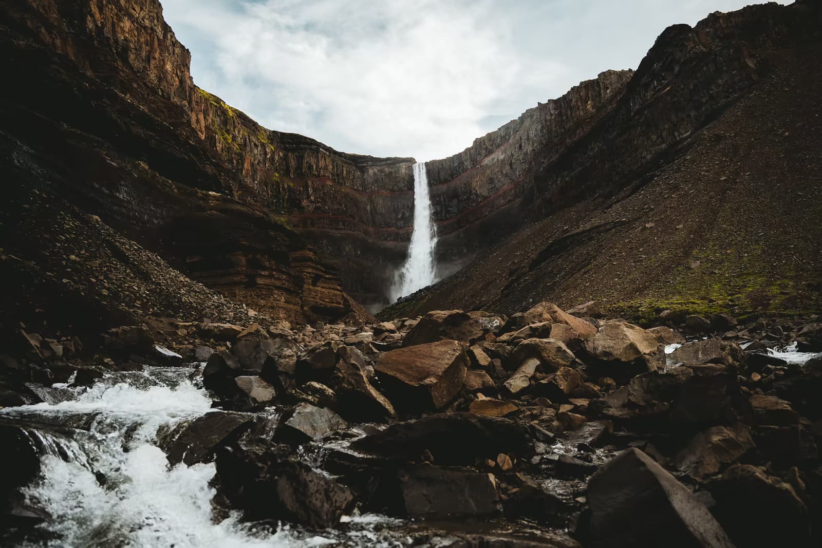 Hengifoss vor dunklen Basaltschichten mit roten Gesteinsbändern