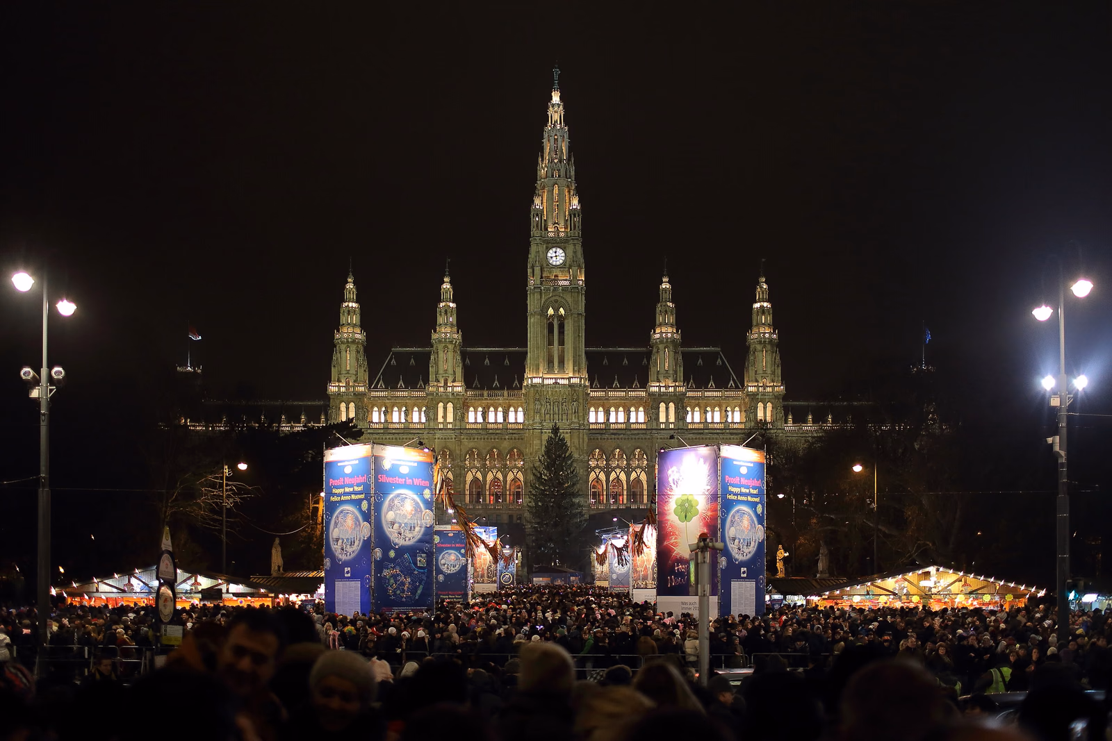 Silvesterpfad auf dem Wiener Rathausplatz: Menschenmenge vor dem beleuchteten Rathaus in der Silvesternacht