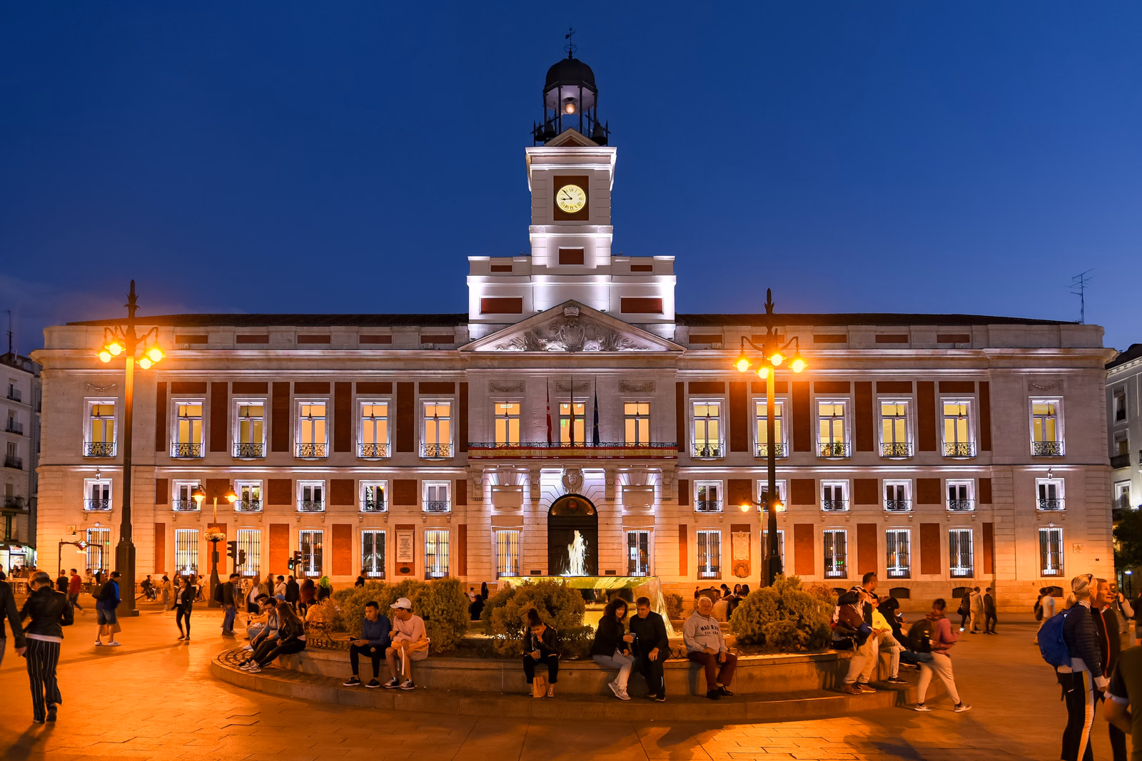 Die beleuchtete Real Casa de Correos mit Uhrturm an der Puerta del Sol in Madrid am Abend