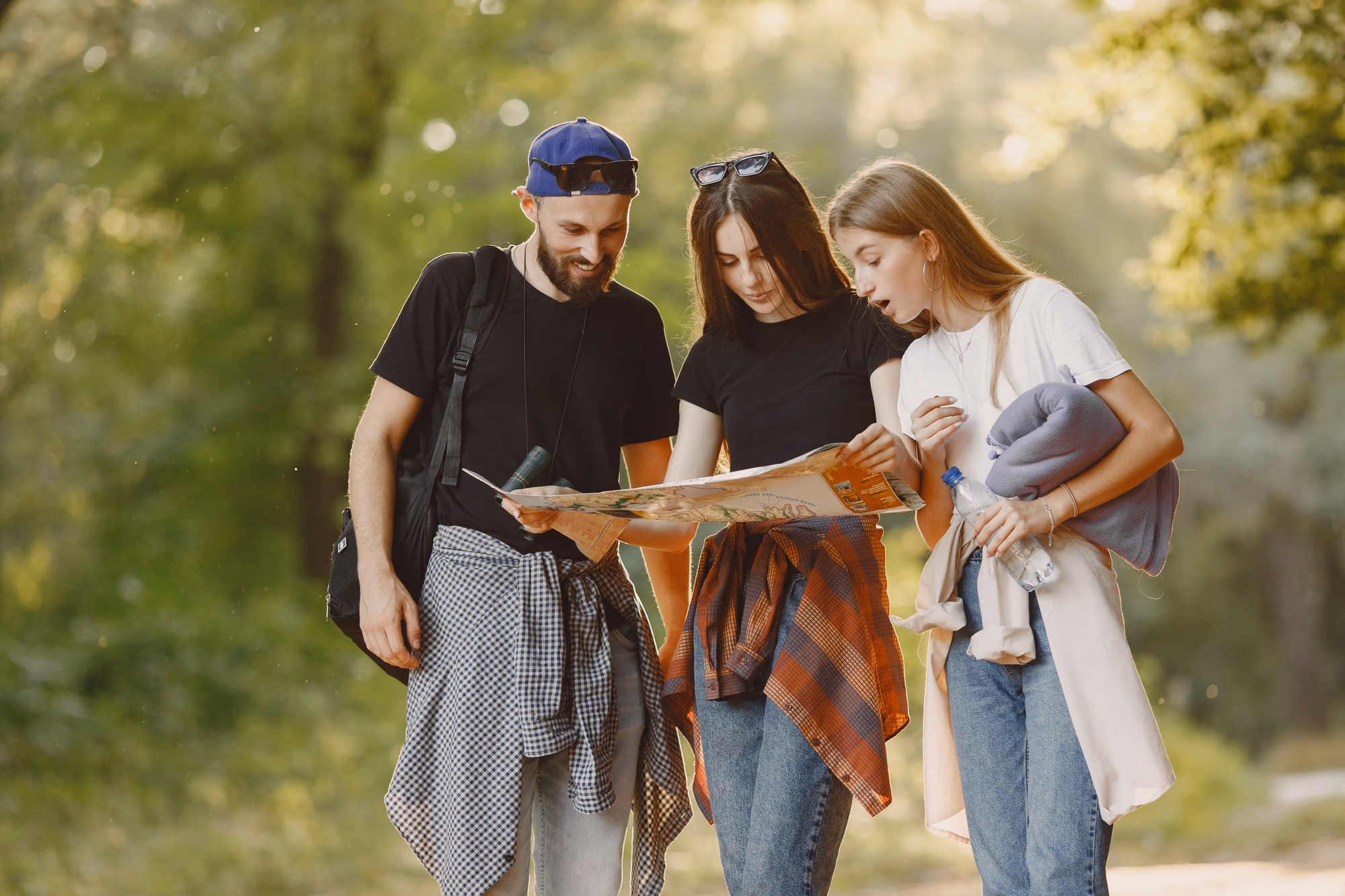 Drei Freunde schauen bei einer Wanderung gemeinsam auf eine Karte