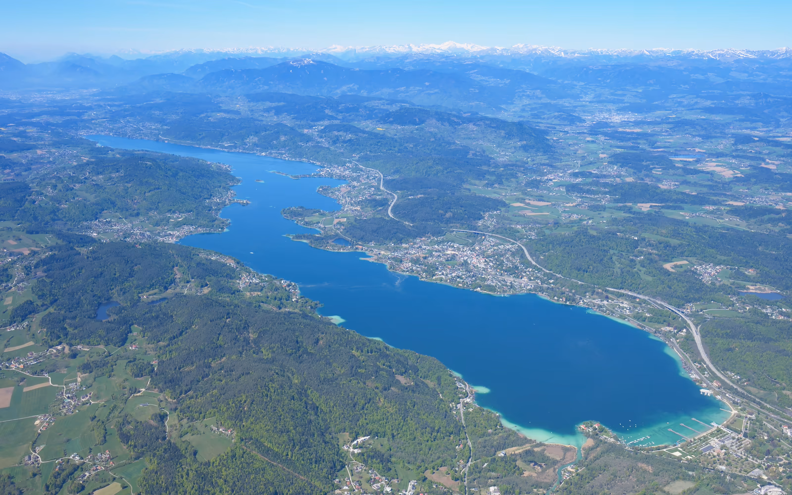 Luftbild des Wörthersees mit Uferorten und umliegender Landschaft